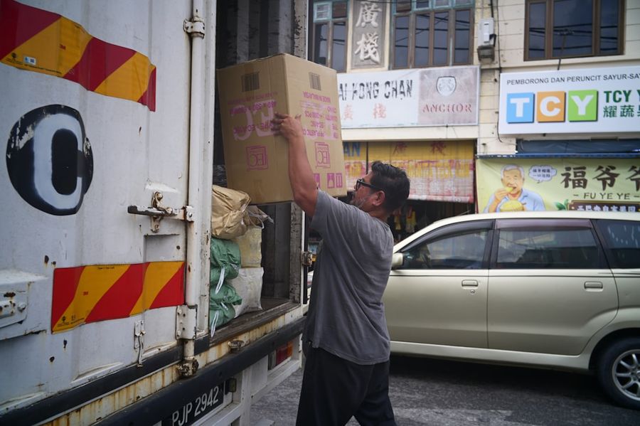 Worker loading cargo boxes into a truck