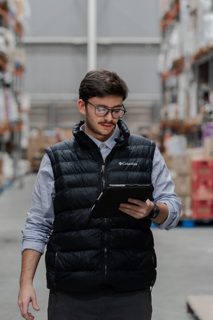 Logistics staff member reviewing shipment details on a tablet in a warehouse